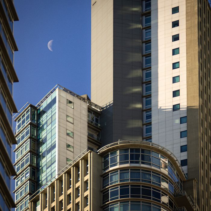 Modern Buenos Aires skyscrapers with a visible daylight moon, showcasing urban architecture.